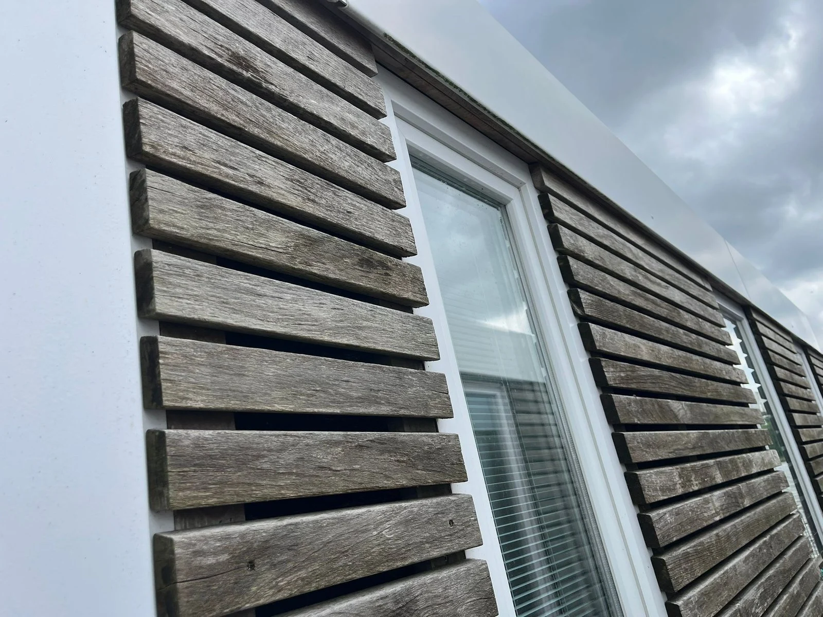 Gepflegte Glasflächen und Holzfassade aus der Tomas Reinigung Projektgalerie